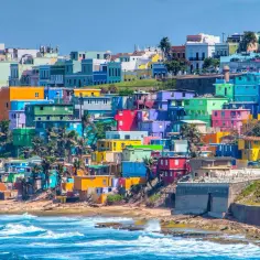 Kolorowe domy na wzgórzu nad oceanem, typowe dla krajobrazu Puerto Rico, gdzie jest to miejsce pełne słońca i życia.