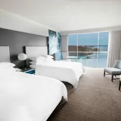 Pokój hotelowy z widokiem na wodospad Niagara. Dwa łóżka, wygodne fotele i okno z panoramą. Warto poznać wodospad Niagara informacje!