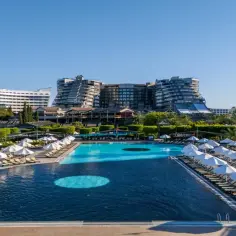 Luksusowy basen z leżakami i parasolami w hotelu Limak Lara De Luxe.