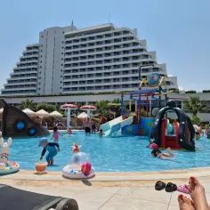 Basen z atrakcjami wodnymi dla dzieci przy hotelu Palm Wings Ephesus. Słoneczny dzień, woda, zjeżdżalnie i dmuchane zabawki.