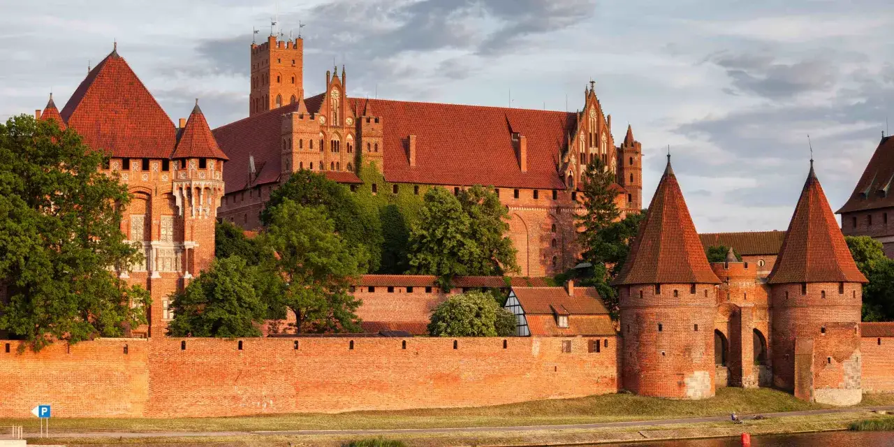 Imponujący zamek z czerwonej cegły, z wieżami i murami obronnymi, to jedno z tych miejsc do zwiedzania, które zapierają dech w piersiach.