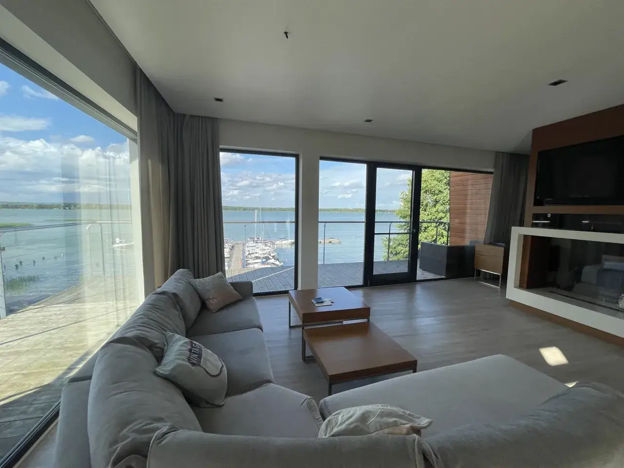 Nowoczesne pokoje nad jeziorem z widokiem na marinę. Wygodna sofa i stoliki kawowe zapraszają do relaksu.