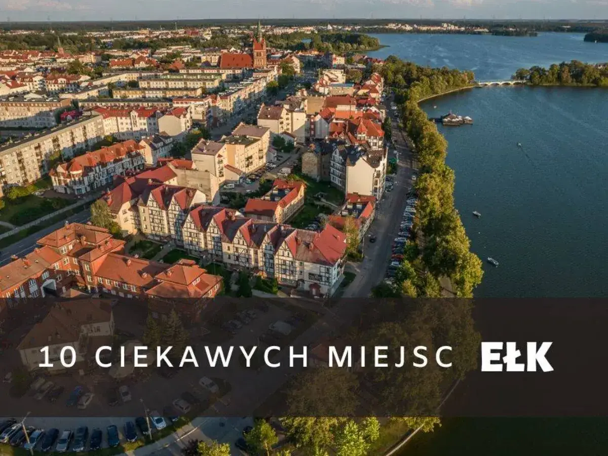 Widok na Ełk, największe miasto Mazur, z jeziorem i zabudową miejską.