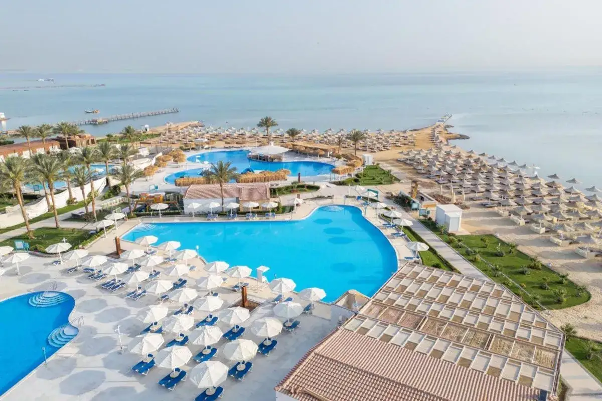 Widok z lotu ptaka na luksusowy Pharaoh Azur Resort z basenami, plażą i morzem.
