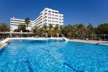 Słoneczny dzień w **sural garden Turcja**. Duży basen z błękitną wodą, palmy i biały hotel tworzą wakacyjny klimat.