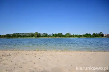 Piękny, słoneczny dzień nad jeziorem gołuchowskim. Piaszczysta plaża i spokojna tafla wody zapraszają do wypoczynku.